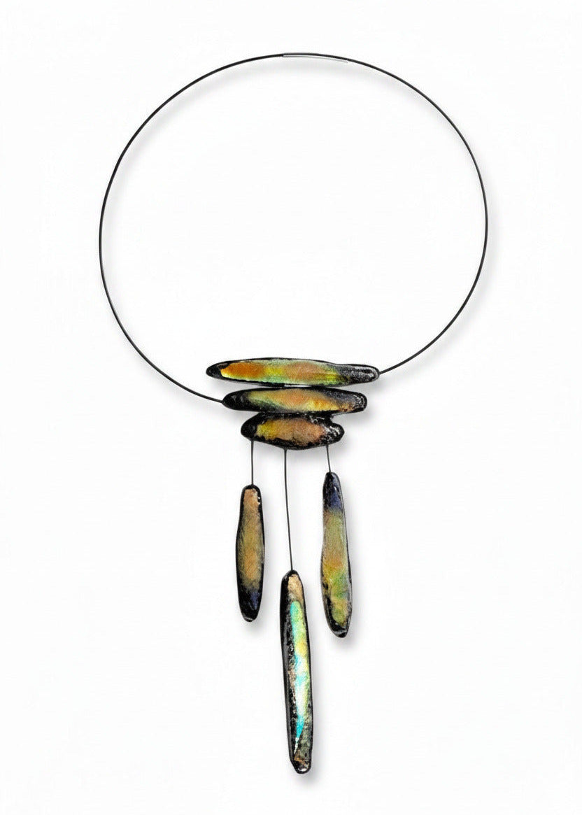 Collier graphique composé d'éléments en forme de stalactites en résine irisée verte sur câble noir. Fermoir aimanté intégré. Création artisanale française légère et contemporaine.