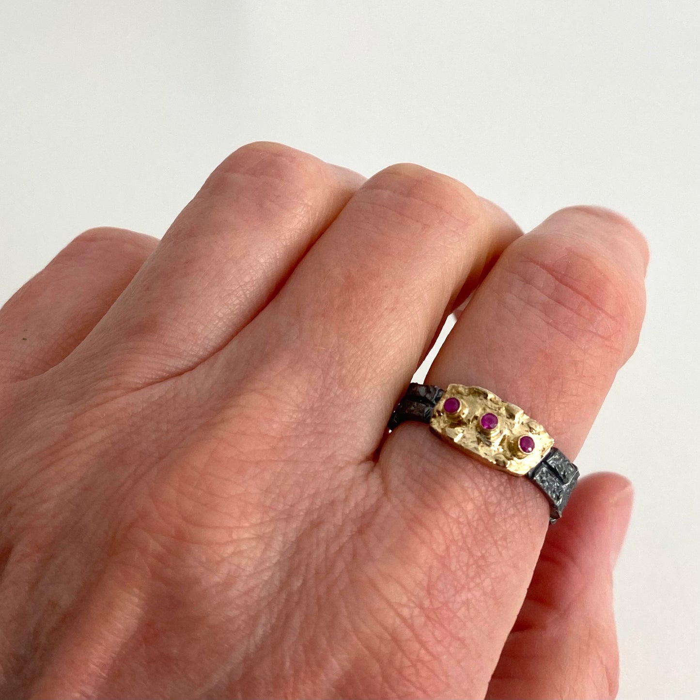 Bague argent patiné,texturé, rehaussé d'or jaune et 3 rubis alignés.