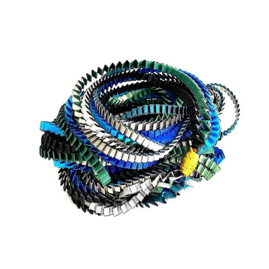 Long collier façonné de huit bandes de tissus plissés et satinés de couleurs : bleu, vert foncé, turquoise, argenté, noir. Chaque bandes est réliées par un lien de coton jaune.