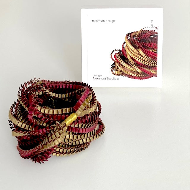 Collier Alexandra Tsoukala en satin plissé bordeaux et olive, présenté dans sa boîte blanche.