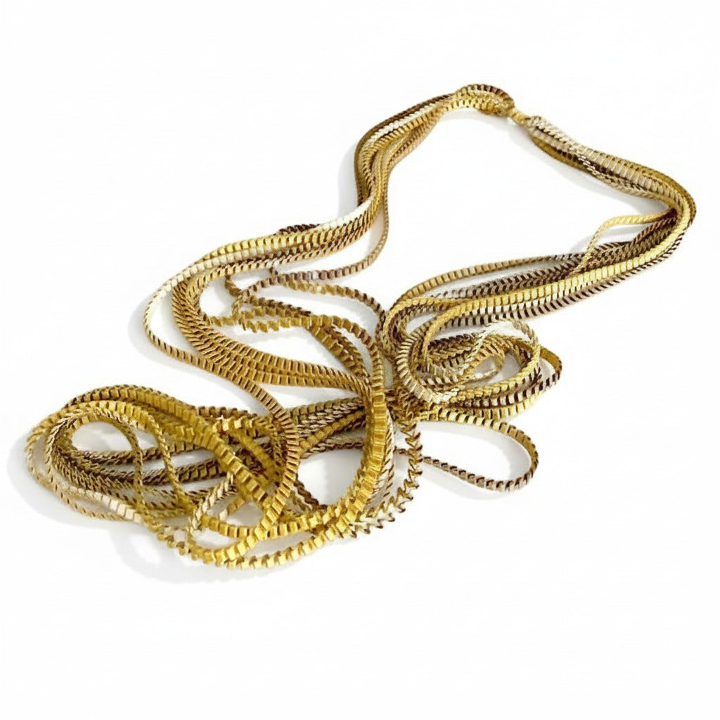 Long sautoir de couleur ivoire , kaki et doré composé de huit bandes de trois millimètres de satin plissé reliées les unes aux autres par un lien de coton jaune d'or.