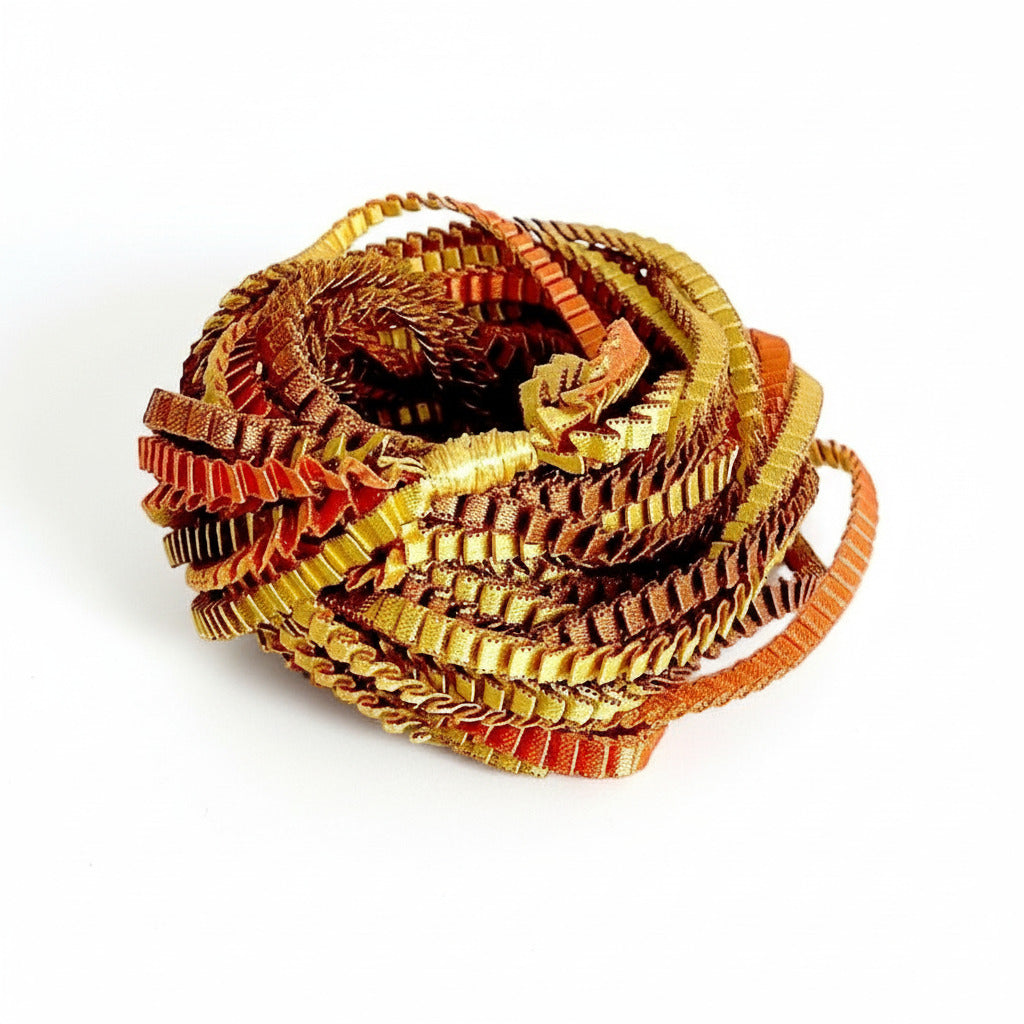 Long sautoir de couleur marron, doré, cuivré composé de huit bandes de trois millimètres de satin plissé reliées les unes aux autres par un lien de coton jaune d'or.
