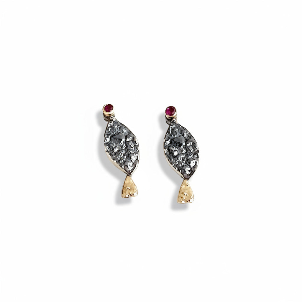 Boucles d'oreilles en forme de petit poisson stylisé. La tête est ornée d'un rubis serti sur le lobe, le corps en argent patiné et texturé, la queue se pare d'or jaune. 