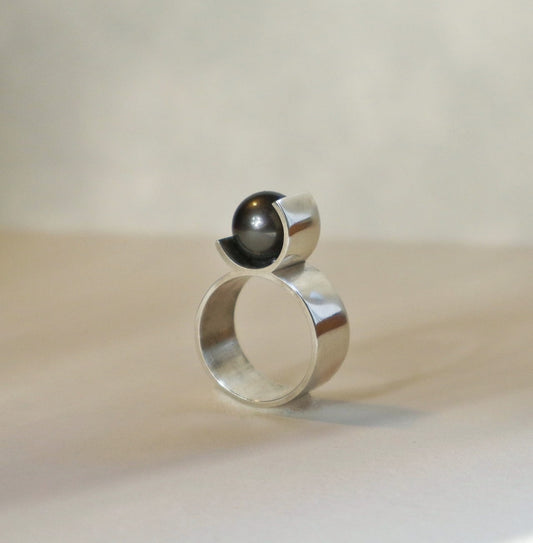 Bijou minimaliste en argent avec perle centrale de Tahiti noire. Une création graphique signée Atelier Grandval.