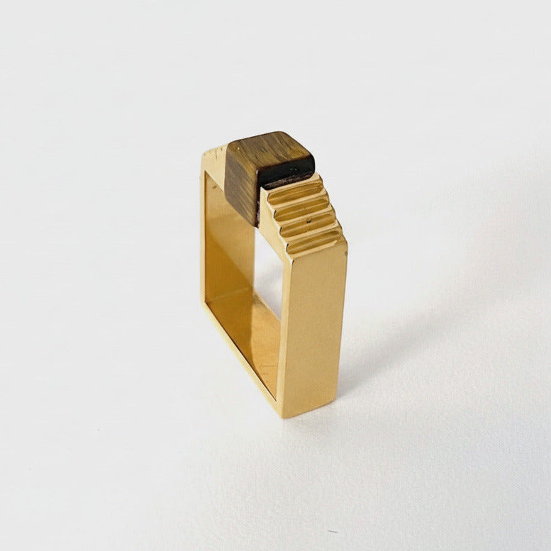 Bague carrée en vermeil avec une pierre oeil de tigre en forme de cube, imbriqué entre deux éléments en formes d'escalier.