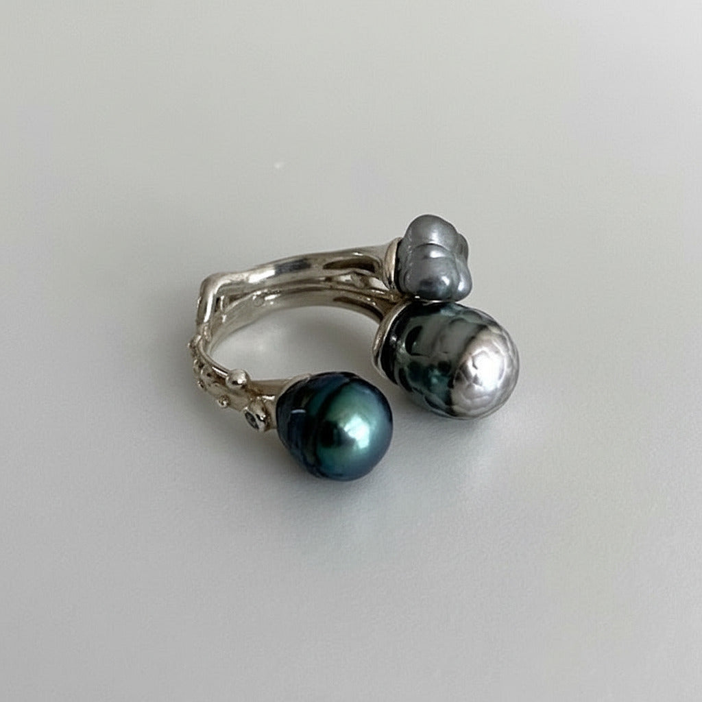 Bague ouverte présentant deux perles de Tahiti  sculptée,de couleurs différentes et une perle keshi carrée.L'anneau en argent est orné de petites pierres de couleurs.Une pièce unique faite à la main par Ivan Michelson.