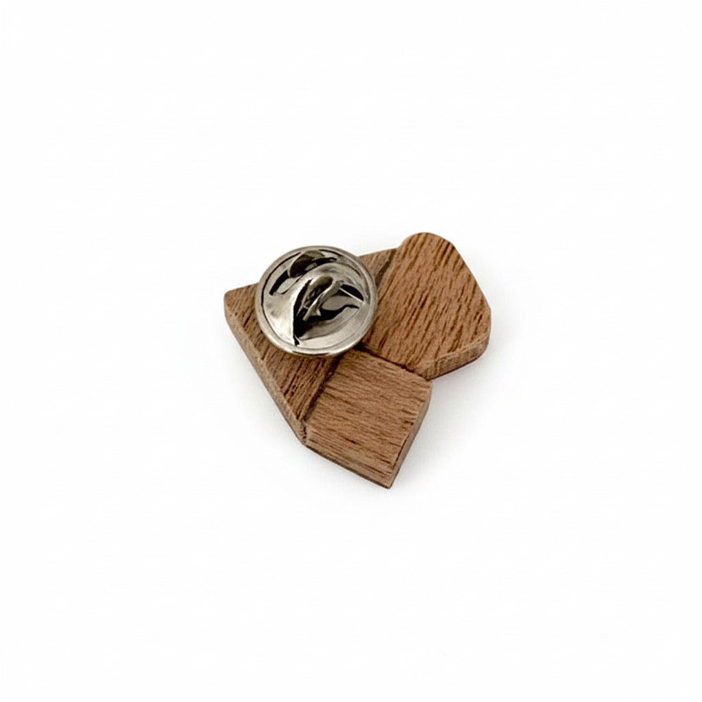Détail petite broche graphique, création contemporaine en bois et formica avec fermoir pin's en acier.