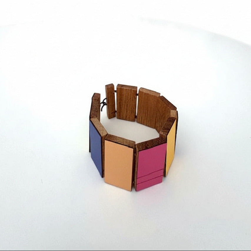 Bracelet contemporain en bois avec rectangles géométriques articulés couverts de formica de différentes couleurs: rose foncé, kaki, bleu, jaune,beige.