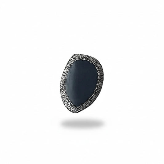Broche unique en corne noire ornée d'une frise de 50 mm composée de points blancs peints à la main, rappelant le pointillisme de l'art aborigène. De mini perles d'hématites soulignent ce travail abstrait. 
