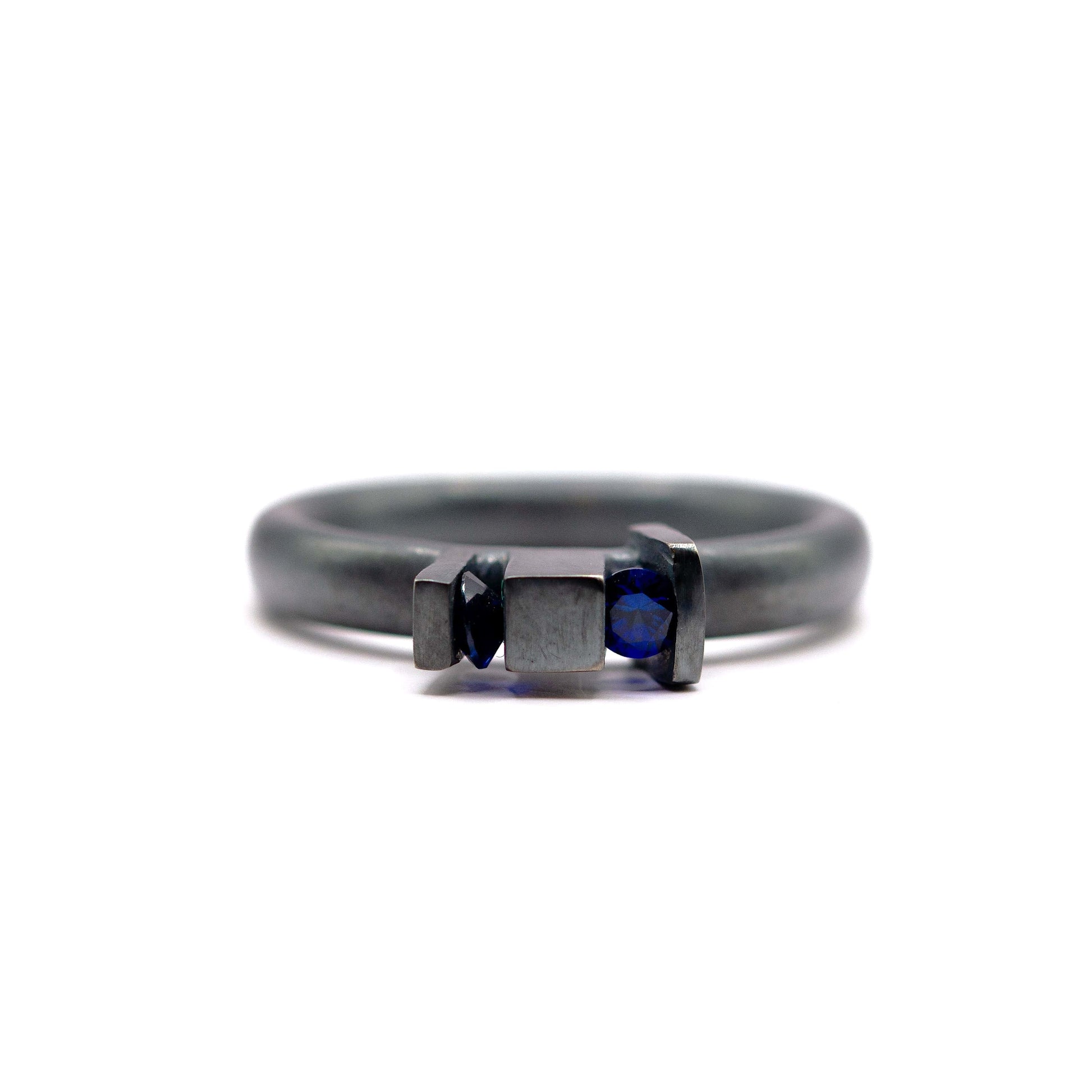 Bague Skyline en argent oxydé avec design géométrique inspiré de l'architecture et deux saphirs de culture bleus.