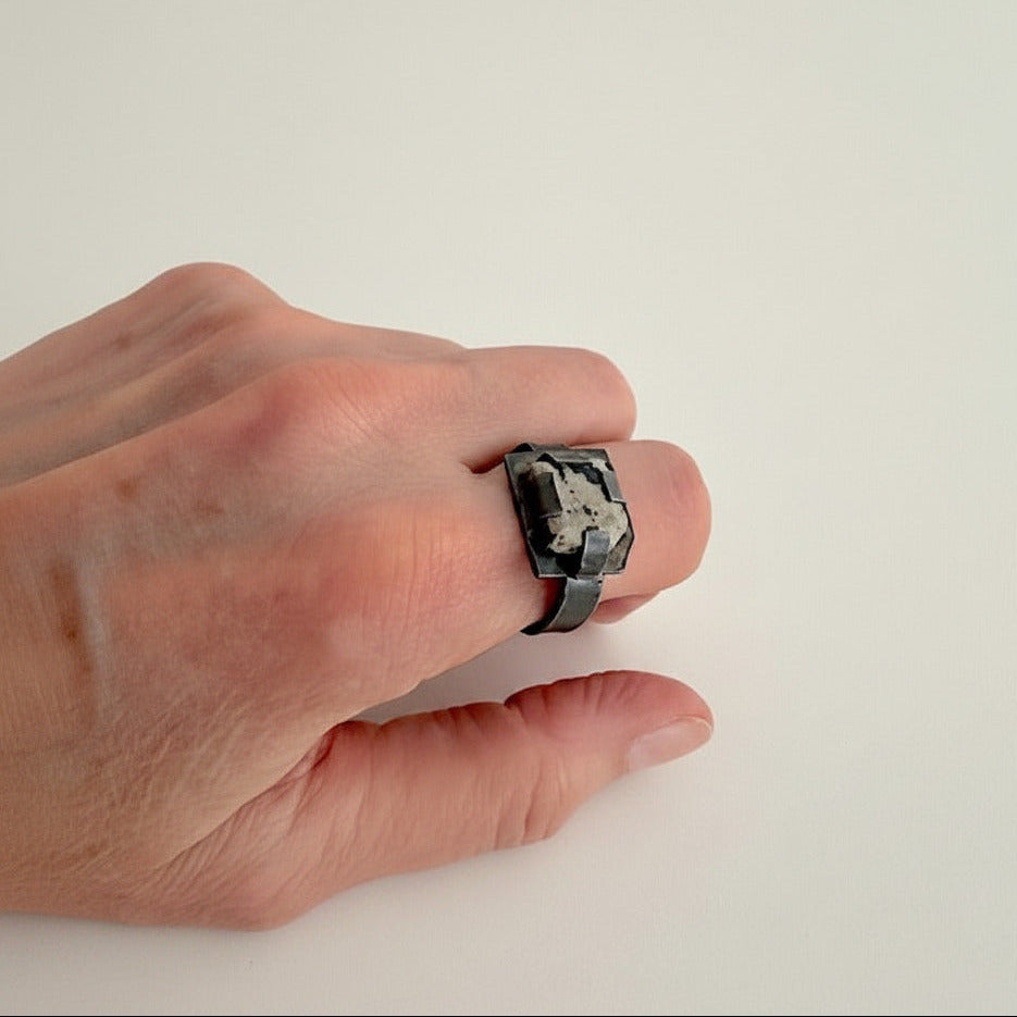 Détail bague contemporaine en argent oxydé et jaspe dalmatien. Quatre griffes plates maintiennent la pierre tout en laissant largement apparaître sa matière, et son dessin naturel.