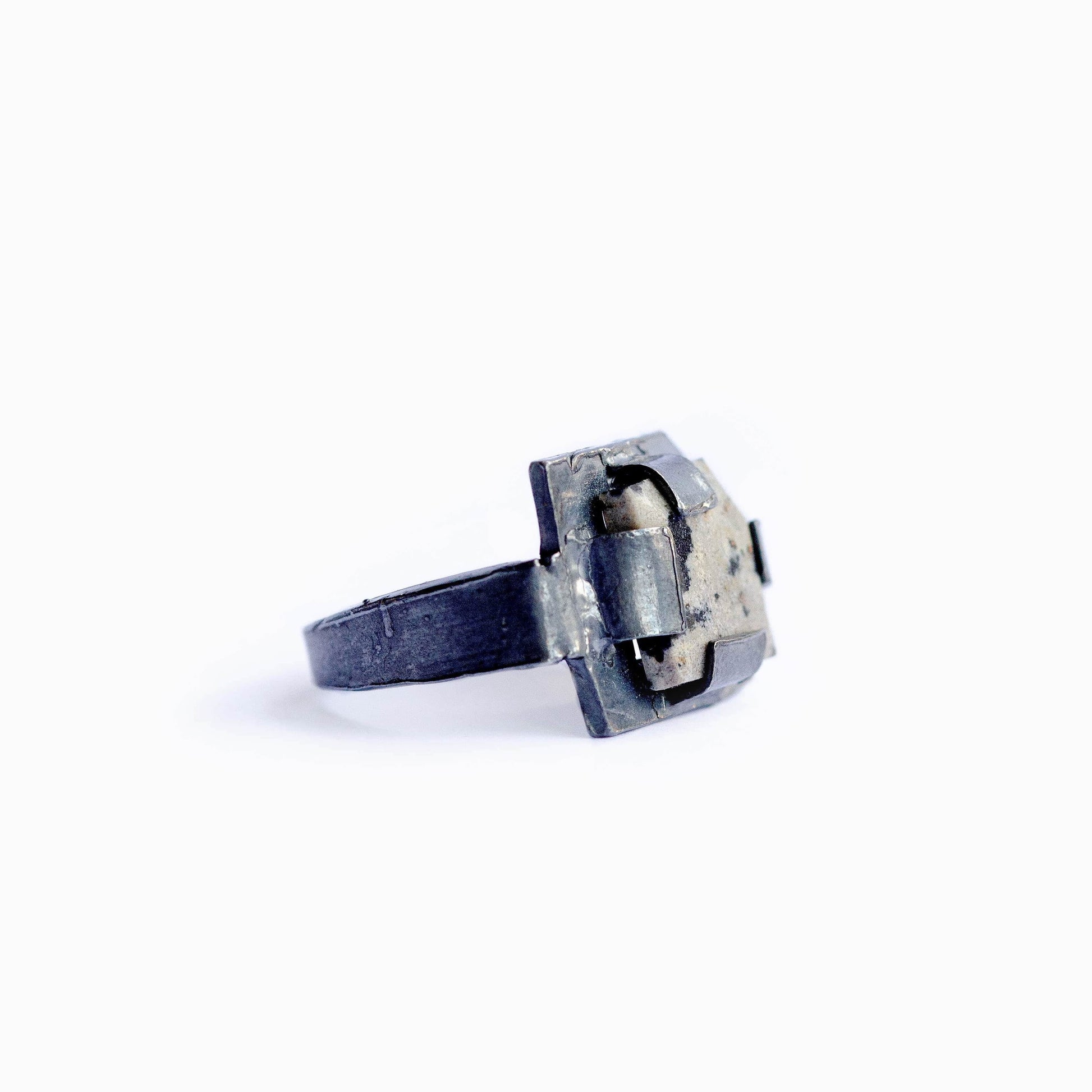 Bague géométrique en argent oxydé et jaspe dalmatien, une création contemporaine au sertissage fragmenté qui révèle une pierre naturelle. 