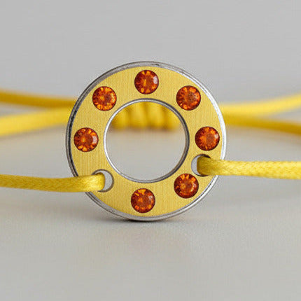 Bracelet Ready-Made, rondelle en  aluminium jaune serti de six opales de feu. bijou contemporain et unisex présenté sur lien de coton réglable jaune. 