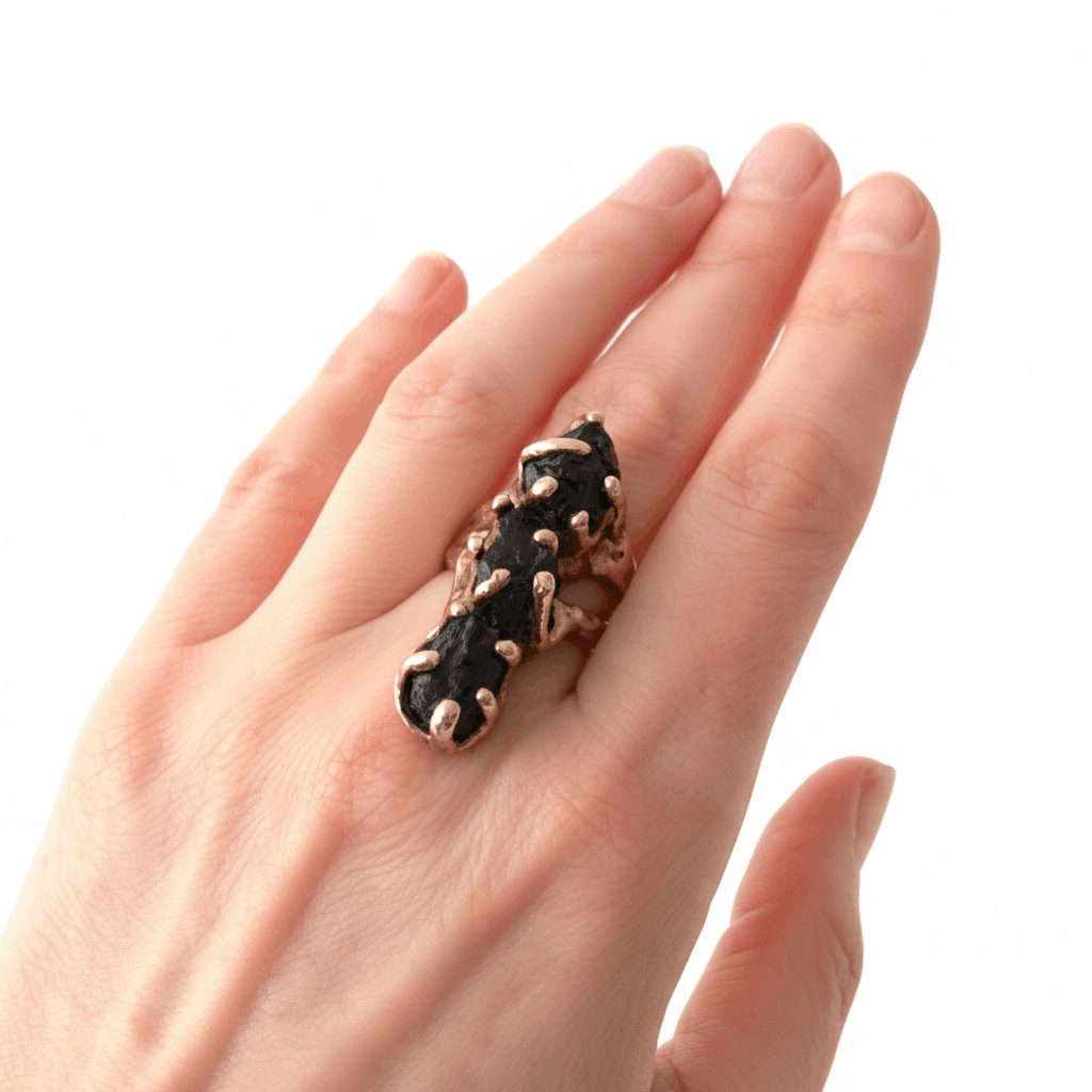 Bague contemporaine en bronze de forme allongée sertie de trois tourmalines noires. Bijou porté.