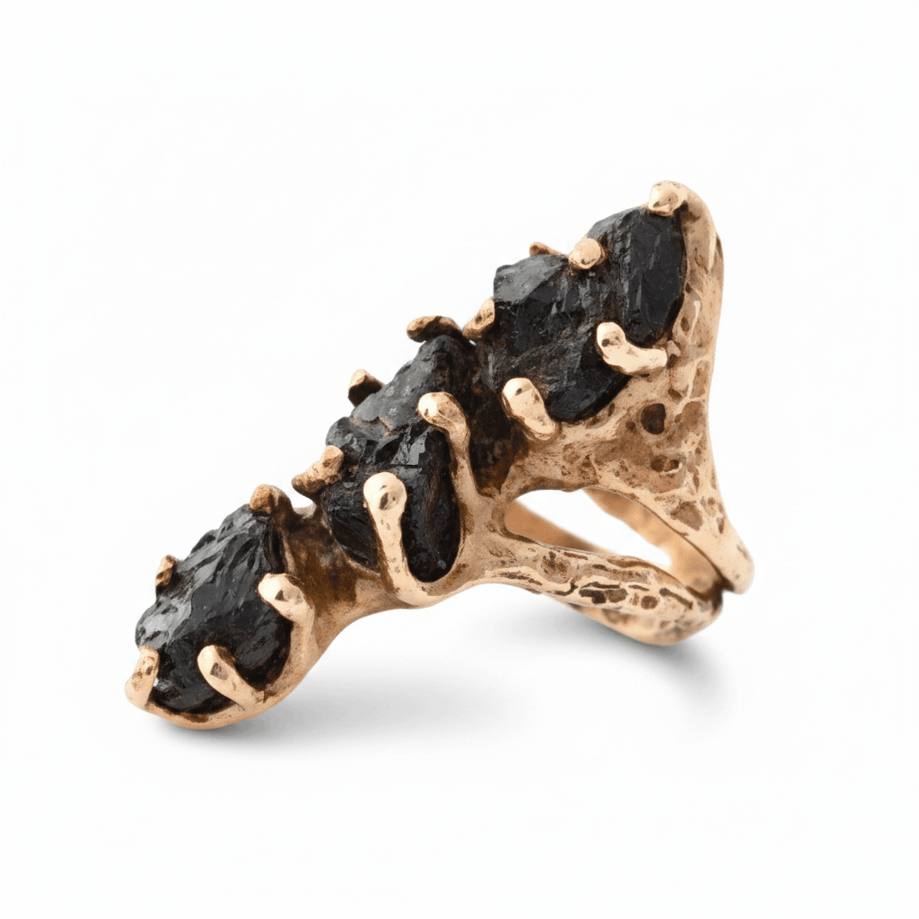 Bague sculpturale en bronze avec une forme allongée sertie de trois tourmalines noires.