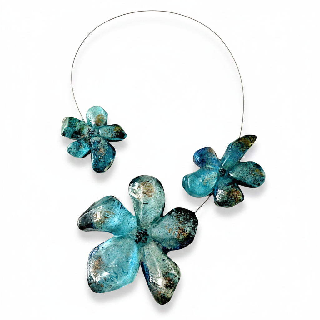 Collier 3 fleurs en résine bleu aux reflets irisés, cable acier noir. Fermoir aimanté à l'avant inséré dans les éléments.