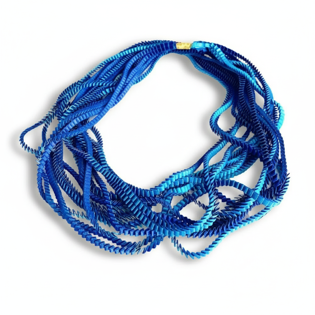 Long collier coloré composé de huit bandes de satin plissé bleu royal,turquoise reliées les unes aux autres par un lien de coton jaune 