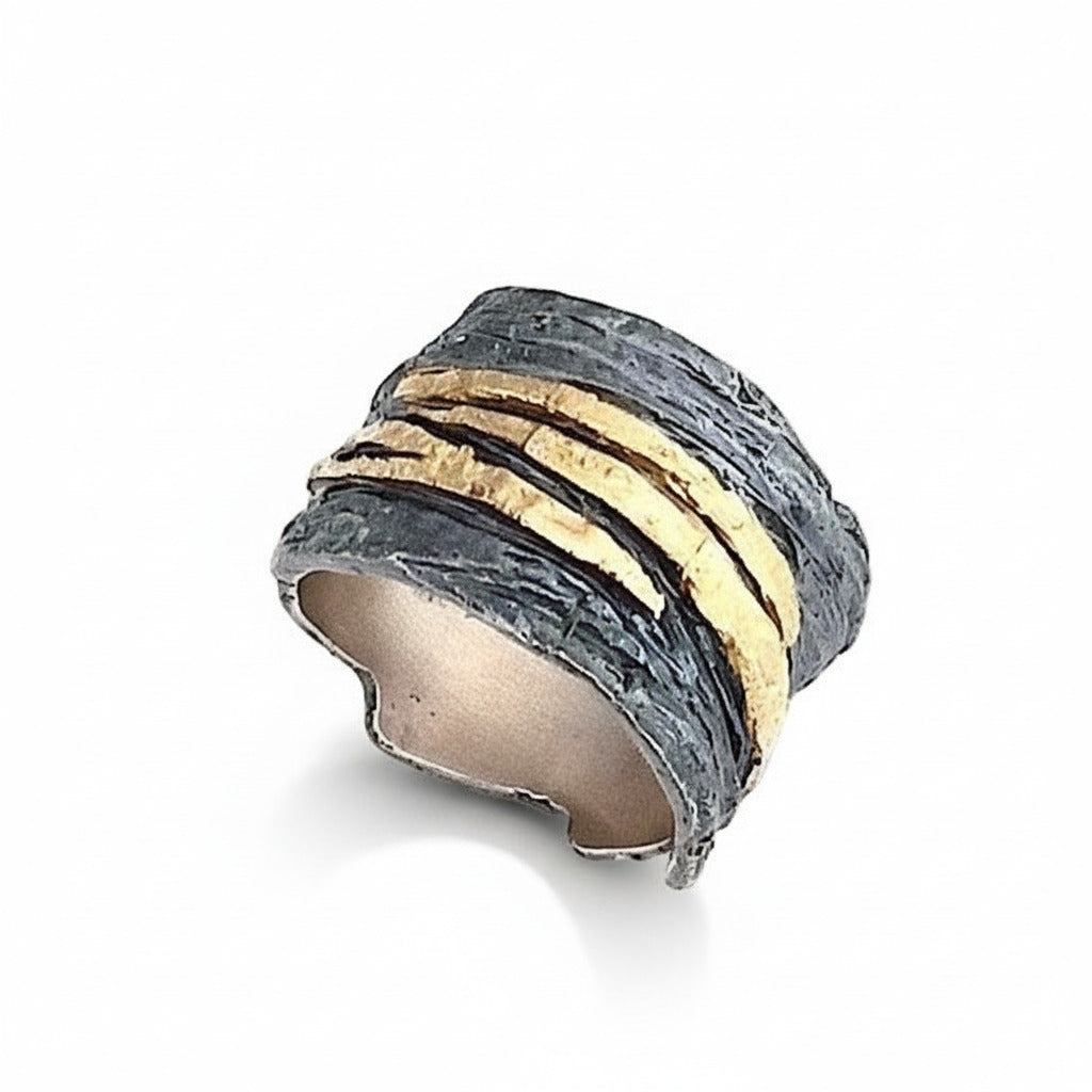Anneau large et irrégulier en argent patiné et strié, orné de bandes or jaune 18K.