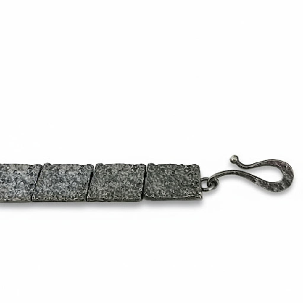 Bracelet articulé argent patiné, composé de 13 éléments rectangulaires, ornés de 5 rectangles or jaune et 3 rubis sertis.Fermoir crochet. 