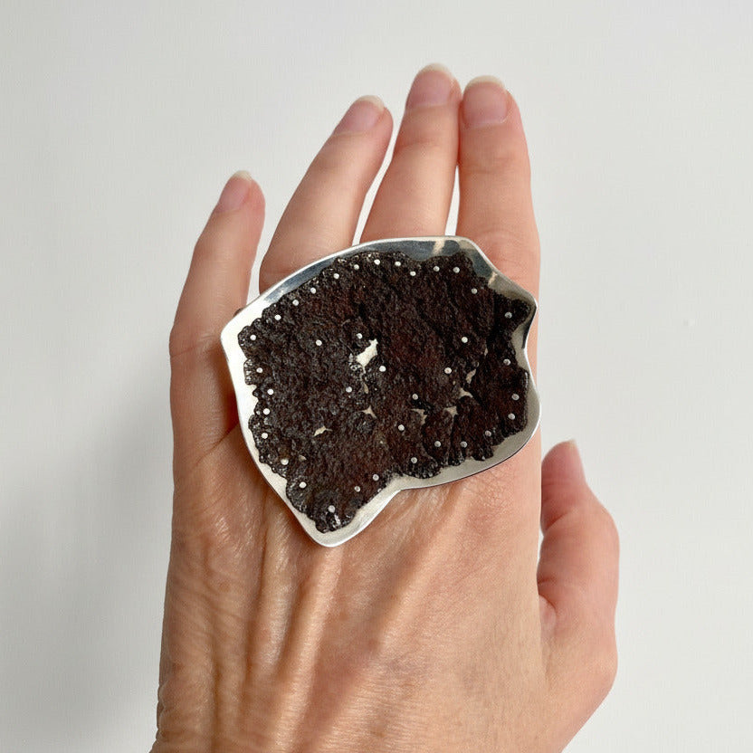 Bague sculpturale en argent et fer rouillé, monté sur un anneau rond mobile.le métal usé à l'extrême est riveté sur plaque d'argent.pièce d'artiste