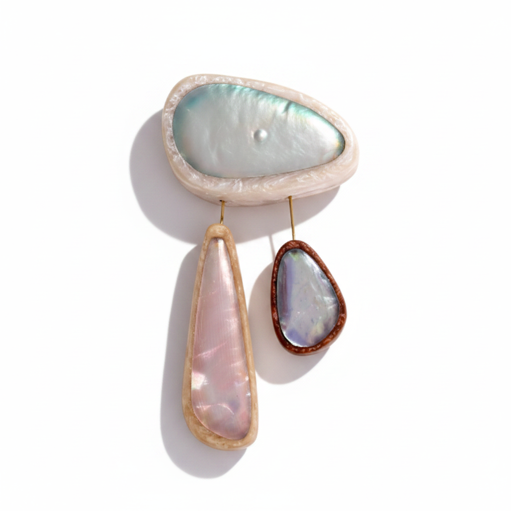 Broche contemporaine composée de 3 éléments de différentes tailles en résine couleurs pastel bleu clair,rose,bleu. les deux petits éléments sont reliés au grand par un cable rigide noir. fermeture aimant