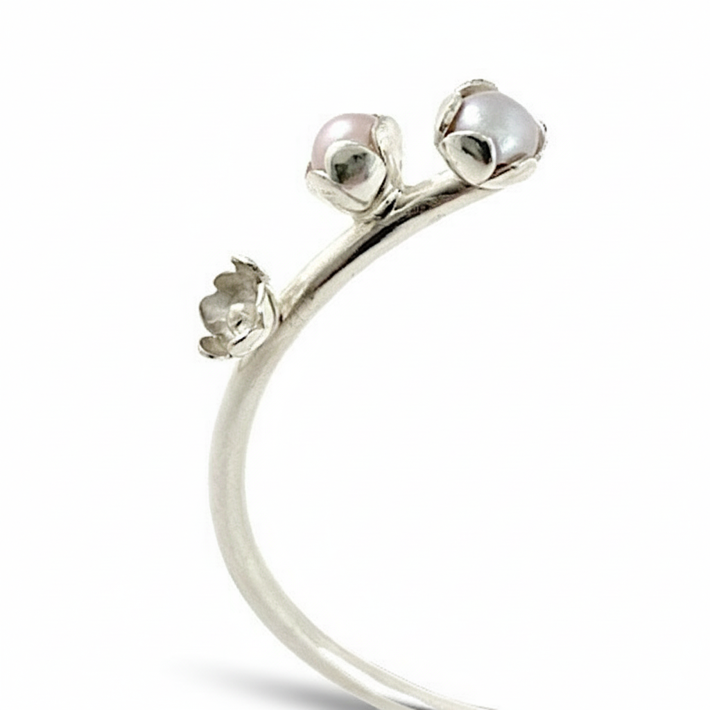 Bracelet jonc en argent orné de trois motifs de fleurs et de trois perles de culture d'eau douce aux couleurs de rose, gris, blanche. Pièce unique faite à la main.
