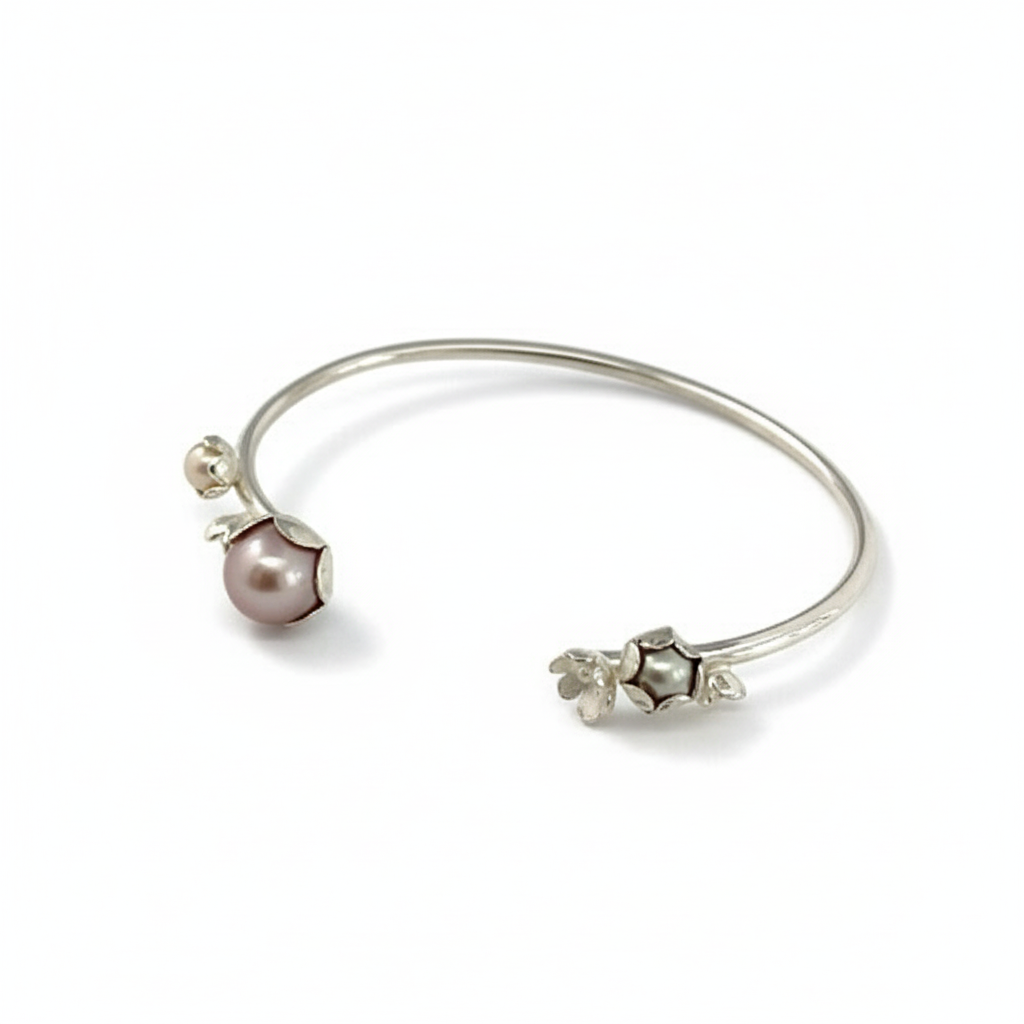 Bracelet jonc argent, orné de quatre motifs de fleurs et de trois perles de culture d'eau douce rose, grise, blanche. Une pièce unique inspirée par la nature façonnée à la main par la créatrice Patricia Lemaire.