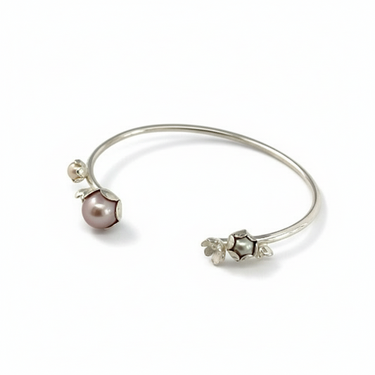 Bracelet jonc argent, orné de quatre motifs de fleurs et de trois perles de culture d'eau douce rose, grise, blanche. Une pièce unique inspirée par la nature façonnée à la main par la créatrice Patricia Lemaire.